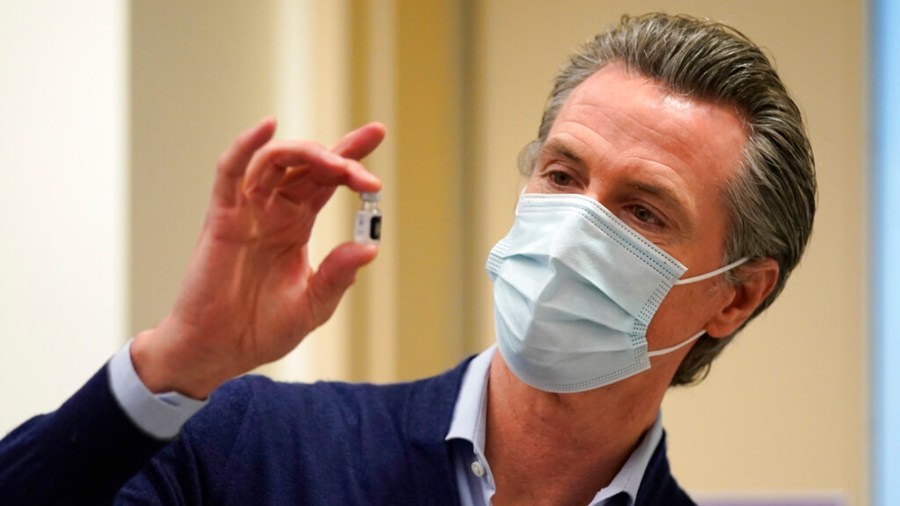 In this Dec. 14, 2020, file photo, California Gov. Gavin Newsom holds up a vial of the Pfizer-BioNTech COVID-19 vaccine at Kaiser Permanente Los Angeles Medical Center in Los Angeles. (AP Photo/Jae C. Hong, File)