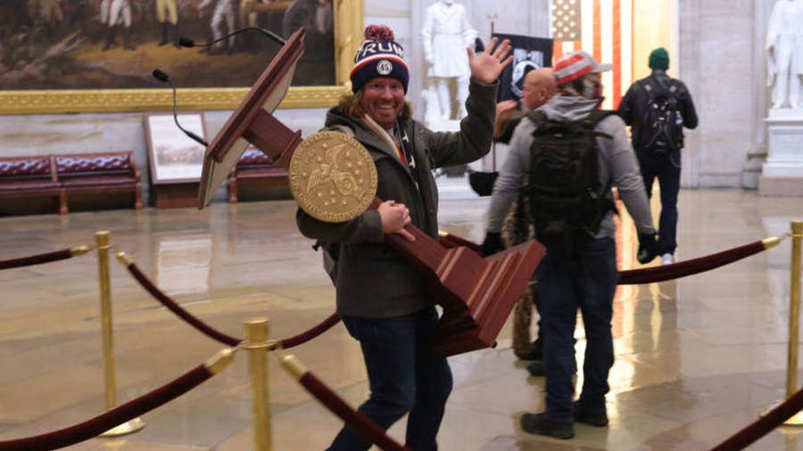 A man, later identified as Adam Johnson of Florida, carries House Speaker Nancy Pelosi's lectern as a mob enters the U.S. Capitol Building on Jan. 6, 2021 in Washington, DC. (Win McNamee/Getty Images)