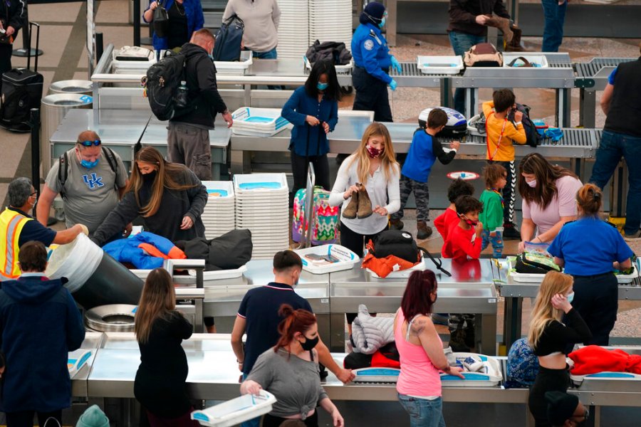 Travelers wear face masks while passing through the south security checkpoint in the main terminal of Denver International Airport Tuesday, Dec. 22, 2020, in Denver. (AP Photo/David Zalubowski)