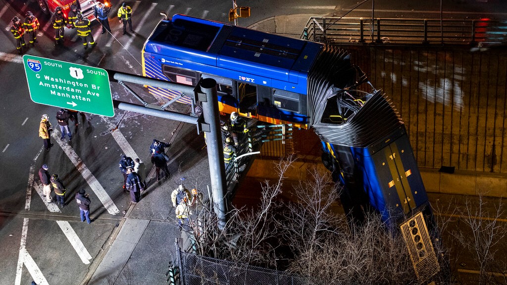 A bus in New York City which careened off a road in the Bronx neighborhood of New York is left dangling from an overpass Friday, Jan. 15, 2021, after a crash late Thursday that left the driver in serious condition, police said. (AP Photo/Craig Ruttle)