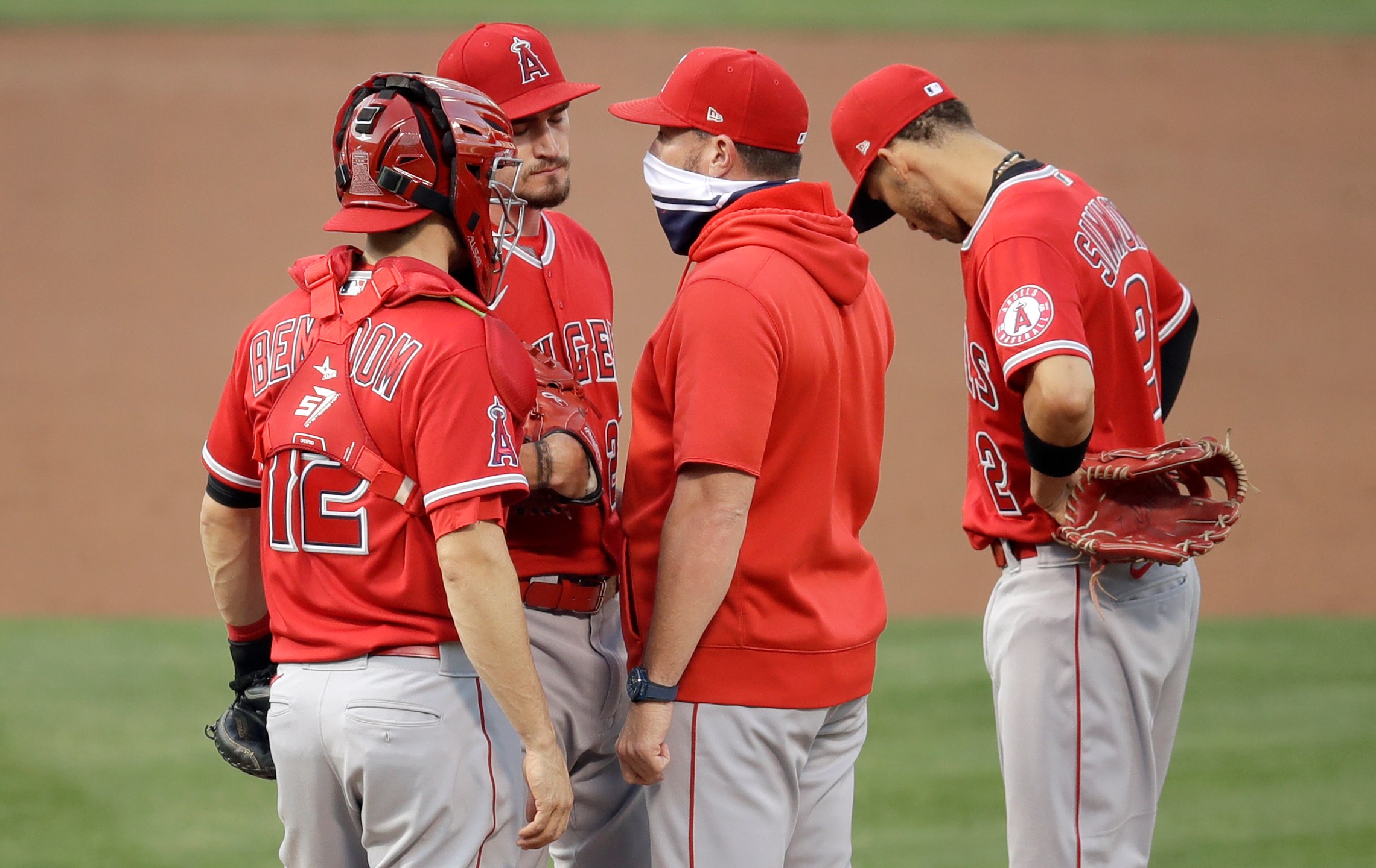 Los Angeles Angels pitcher Andrew Heaney, second from left, speaks with pitching coach Mickey Callaway, second from right, in the first inning of a baseball game against the Oakland Athletics on Aug. 21, 2020, in Oakland. (Ben Margot / Associated Press)