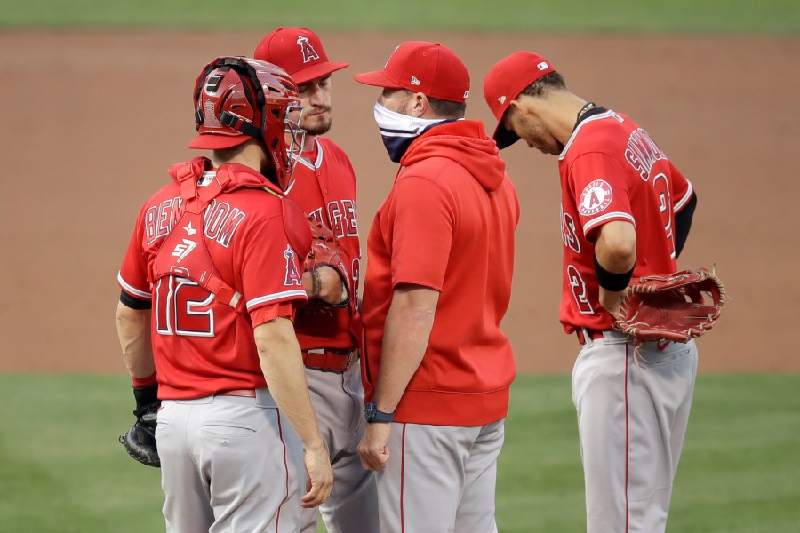 Los Angeles Angels pitcher Andrew Heaney, second from left, speaks with pitching coach Mickey Callaway, second from right, in the first inning of a baseball game against the Oakland Athletics on Aug. 21, 2020, in Oakland. (Ben Margot / Associated Press)