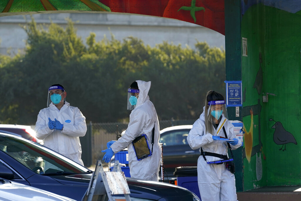 Health care workers prepare coronavirus tests at the CityTestSF at Alemany Farmer's Market in San Francisco , Dec. 22, 2020. (AP Photo/Jeff Chiu)