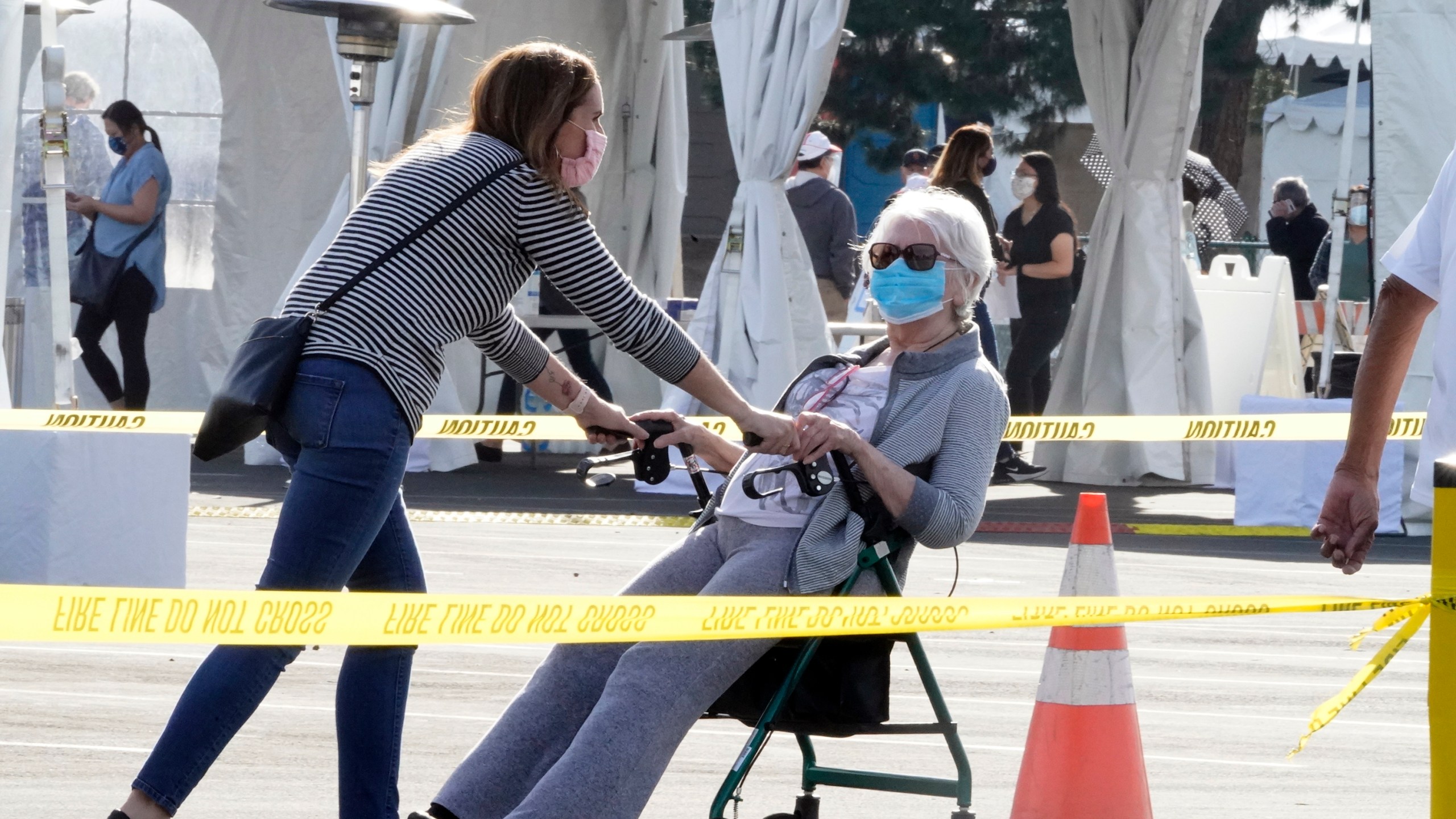 People walk after receiving their vaccines at the Disneyland Resort, serving as a COVID-19 mass vaccination site in Anaheim, on Jan. 13, 2021. (Damian Dovarganes / Associated Press)