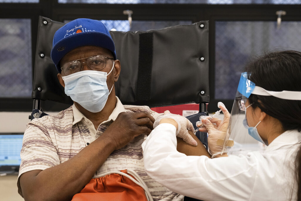 In this Jan. 15, 2021, file photo, a nursing home resident receives the COVID-19 vaccine by a CVS Pharmacist at a nursing home facility in Harlem neighborhood of New York. (AP Photo/Yuki Iwamura)