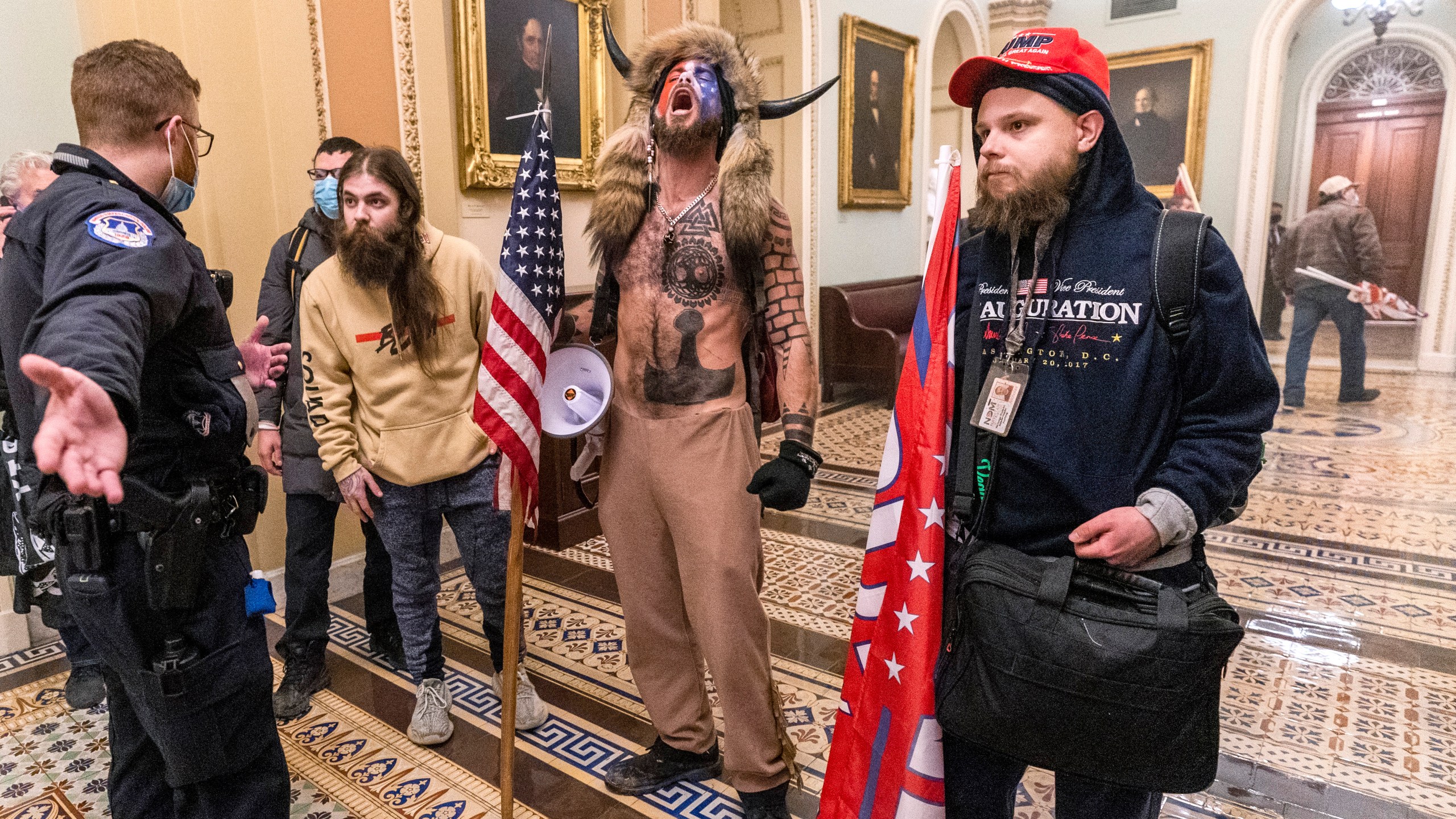 In this Wednesday, Jan. 6, 2021 file photo, supporters of President Donald Trump, including Jacob Chansley, center with fur hat, are confronted by Capitol Police officers outside the Senate Chamber inside the Capitol in Washington. (AP Photo/Manuel Balce Ceneta)