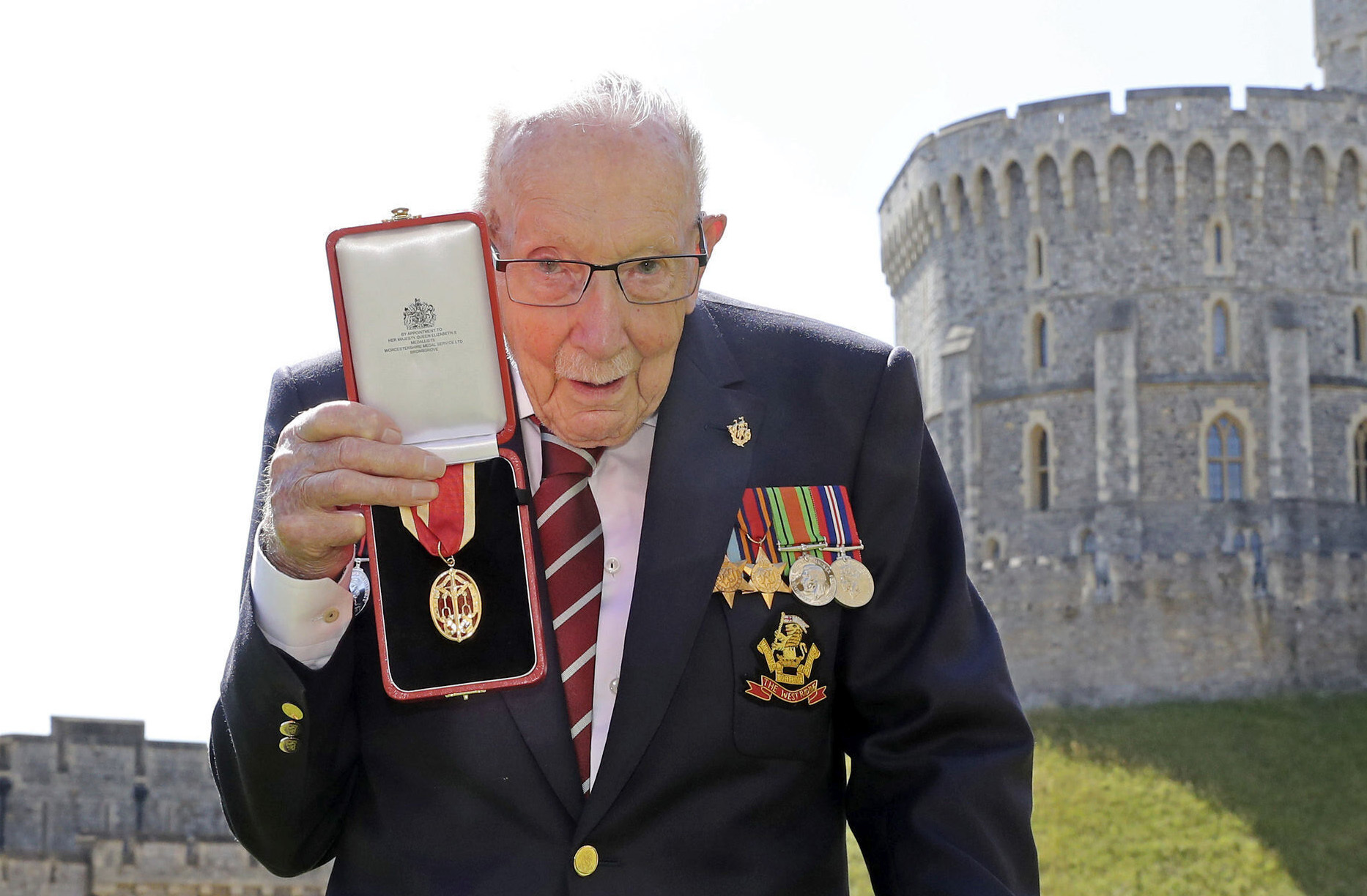 In this Friday, July 17, 2020 file photo, Captain Sir Thomas Moore poses for the media after receiving his knighthood from Britain's Queen Elizabeth, during a ceremony at Windsor Castle in Windsor, England. Tom Moore, the 100-year-old World War II veteran who captivated the British public in the early days of the coronavirus pandemic with his fundraising efforts, has been admitted to a hospital with COVID-19, his daughter said Sunday Jan. 31, 2021. (Chris Jackson/Pool Photo via AP, File)