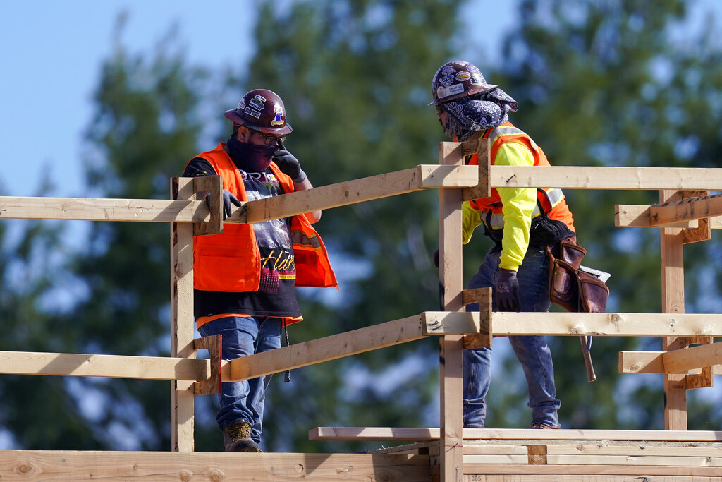 Construction workers talk at a USA Properties Fund site on Feb. 2, 2021, in Simi Valley, Calif. (AP Photo/Mark J. Terrill)