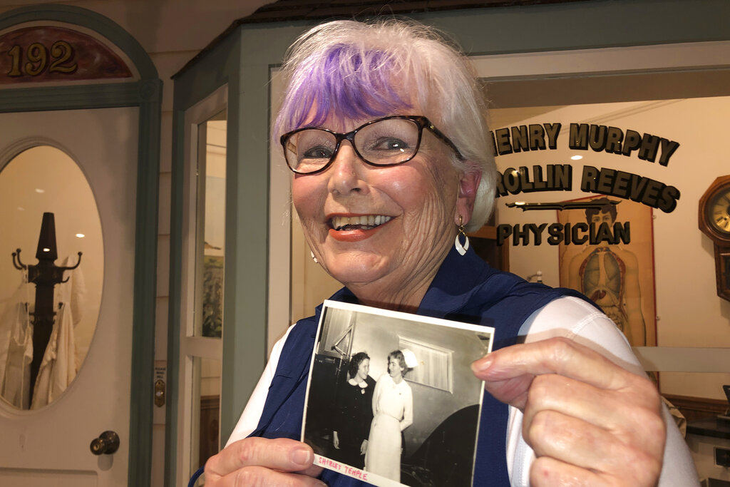 Nurse practitioner Sigrid Stokes, 76, holds a photograph of her mother talking to Shirley Temple, at the Salinas Valley Memorial Hospital in Salinas, Calif., Wednesday, Feb. 3, 2021. (AP Photo/Haven Daley)