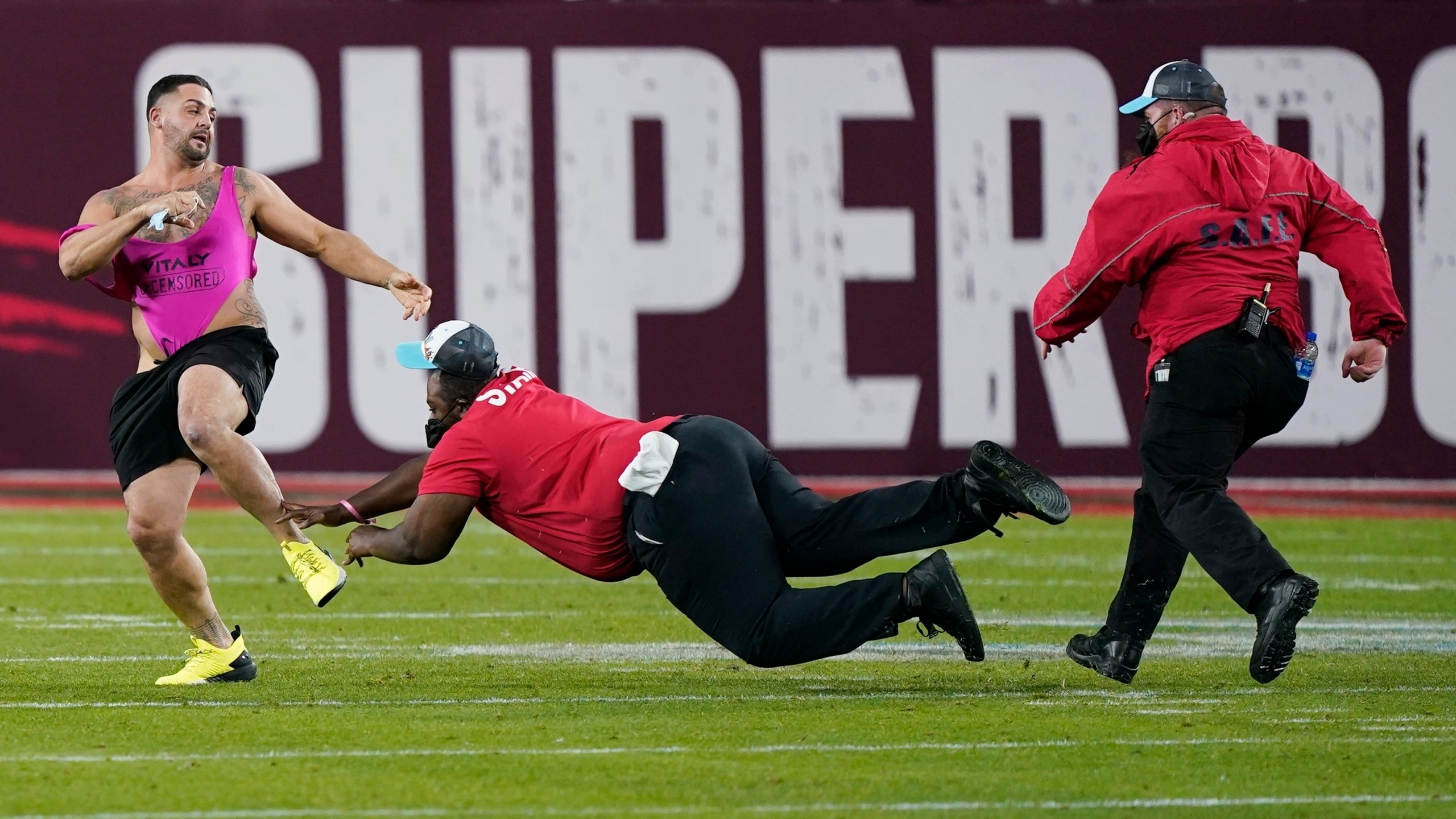 Security tries to grab a fan on the field during the second half of the NFL Super Bowl 55 football game between the Tampa Bay Buccaneers and the Kansas City Chiefs, Sunday, Feb. 7, 2021, in Tampa, Fla. (AP Photo/Mark Humphrey)