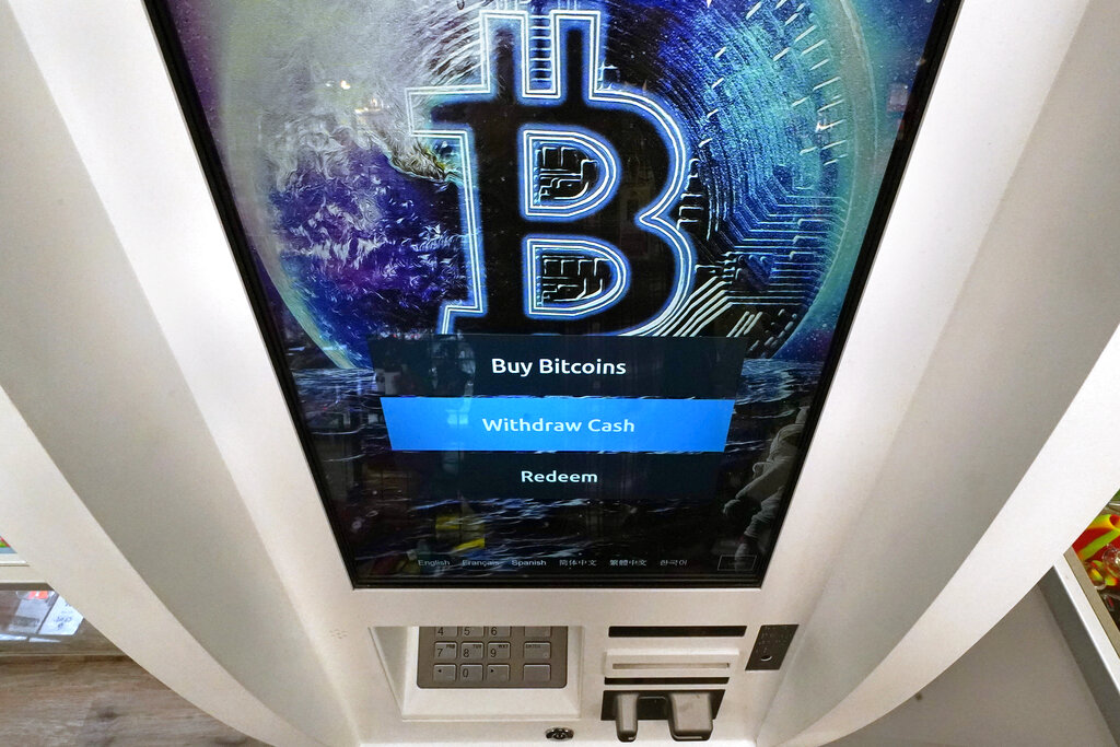 The Bitcoin logo appears on the display screen of a crypto currency ATM at the Smoker's Choice store, Tuesday, Feb. 9, 2021, in Salem, N.H. (AP Photo/Charles Krupa)