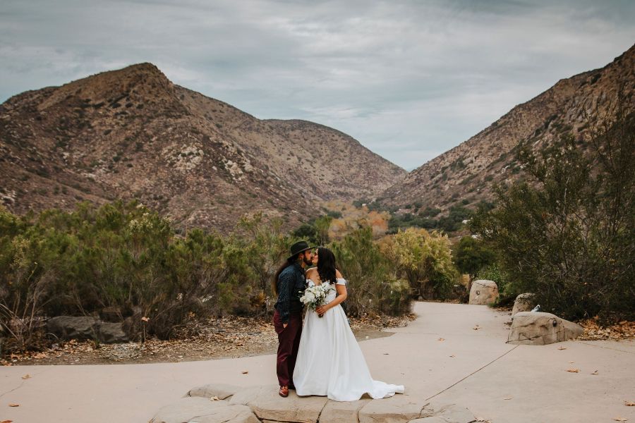 In this Sunday, Dec. 27, 2020 photo provided by Kristen Pritchard Photography, Kayleigh and Cody Cousins pose for wedding photos at Mission Trails Regional Park in San Diego, Calif. They initially planned an April 2020 wedding, postponed it after the pandemic took hold, rescheduled it for December, then had to shift gears again when a new lockdown was imposed. “That was devastating,” said Kayleigh. “We said, ‘Let’s just do it on Zoom.’” (Kristen Pritchard Photography via AP)