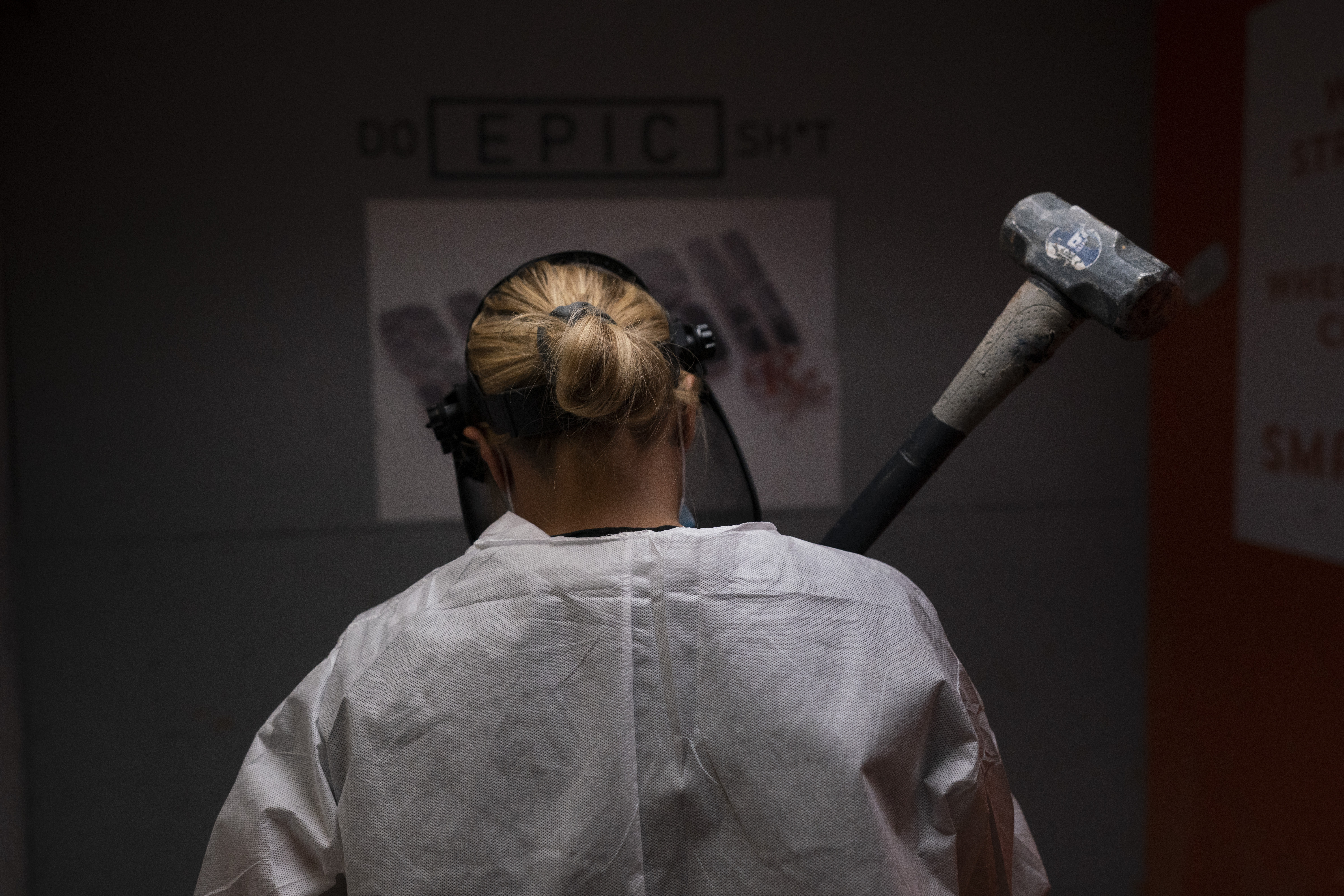 Michelle Elohim, a mother of four children, holds a hammer to smash a side table in a rage room at Smash RX in Westlake Village on Feb. 5, 2021. (Jae C. Hong / Associated Press)