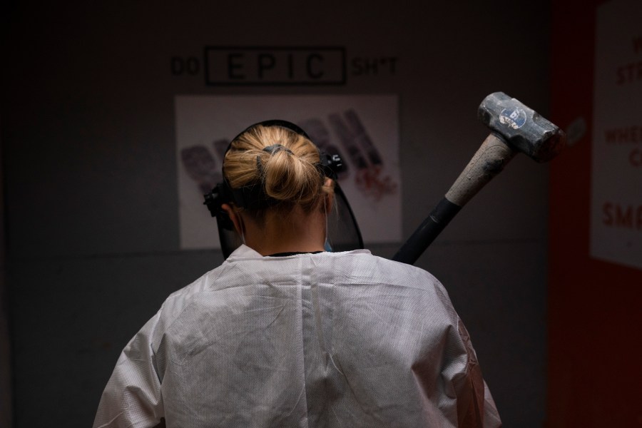 Michelle Elohim, a mother of four children, holds a hammer to smash a side table in a rage room at Smash RX in Westlake Village on Feb. 5, 2021. (Jae C. Hong / Associated Press)