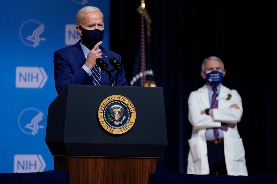 President Joe Biden speaks during a visit to the Viral Pathogenesis Laboratory at the National Institutes of Health in Bethesda, Md. on Feb. 11, 2021 as Dr. Anthony Fauci looks on. (Evan Vucci/Associated Press)