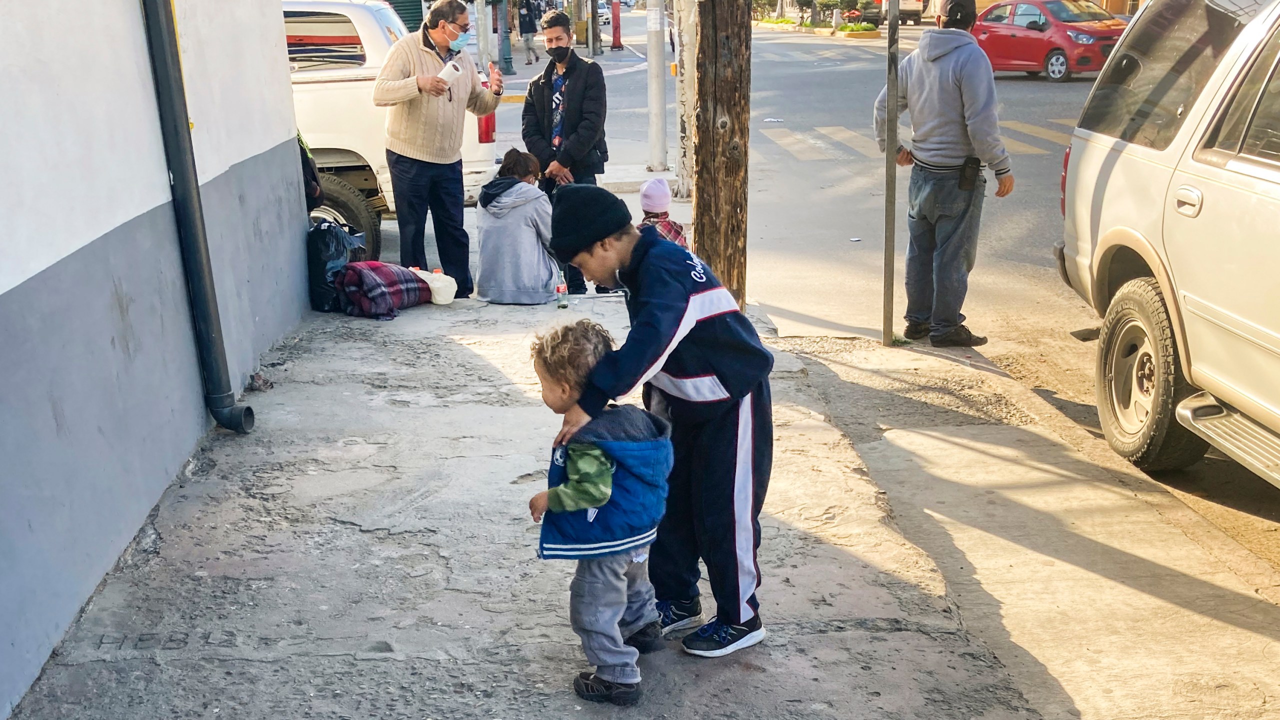 Honduran boys whose family wants to seek asylum in the U.S., play on the sidewalk in Tijuana, Mexico, Monday, Feb. 8, 2021. (AP Photo/Elliot Spagat)