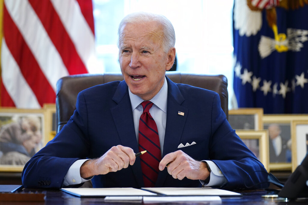 In this Jan. 28, 2021 file photo, President Joe Biden signs a series of executive orders in the Oval Office of the White House in Washington. (AP Photo/Evan Vucci)