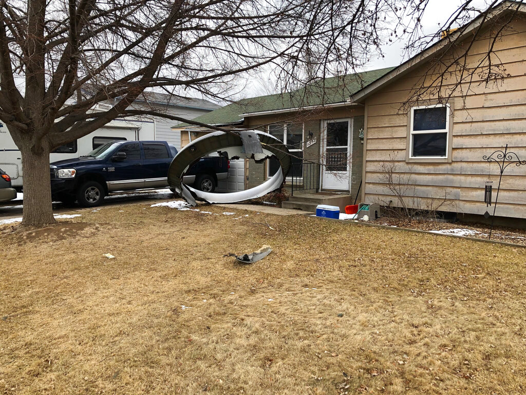 In this photo provided by the Broomfield Police Department on Twitter, debris is scattered in the front yard of a house at near 13th and Elmwood, Saturday, Feb. 20, 2021, in Broomfield, Colo. A commercial airliner dropped debris in Colorado neighborhoods during an emergency landing Saturday. The Broomfield Police Department said on Twitter that the plane landed safely at Denver International Airport and that no injuries had been reported from the incident. (Broomfield Police Department via AP)