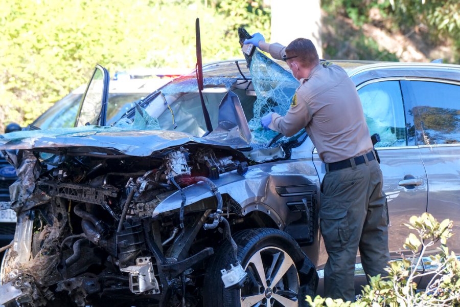 A law enforcement officer looks over a damaged vehicle following a rollover accident involving golfer Tiger Woods, Tuesday, Feb. 23, 2021, in the Rancho Palos Verdes suburb of Los Angeles.(AP Photo/Ringo H.W. Chiu)