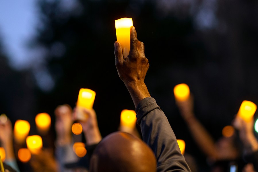 Marchers hold candles up as they listen to a speaker during a march and candlelight vigil for Ahmaud Arbery in Brunswick, Ga., on Feb. 23, 2021. (Stephen B. Morton / Associated Press)