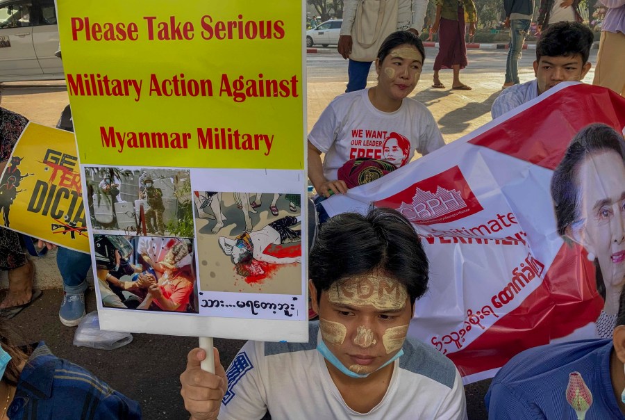 An anti-coup protester holds a placard requesting military action against Myanmar military in Yangon, Myanmar on Feb. 25, 2021. (AP Photo)