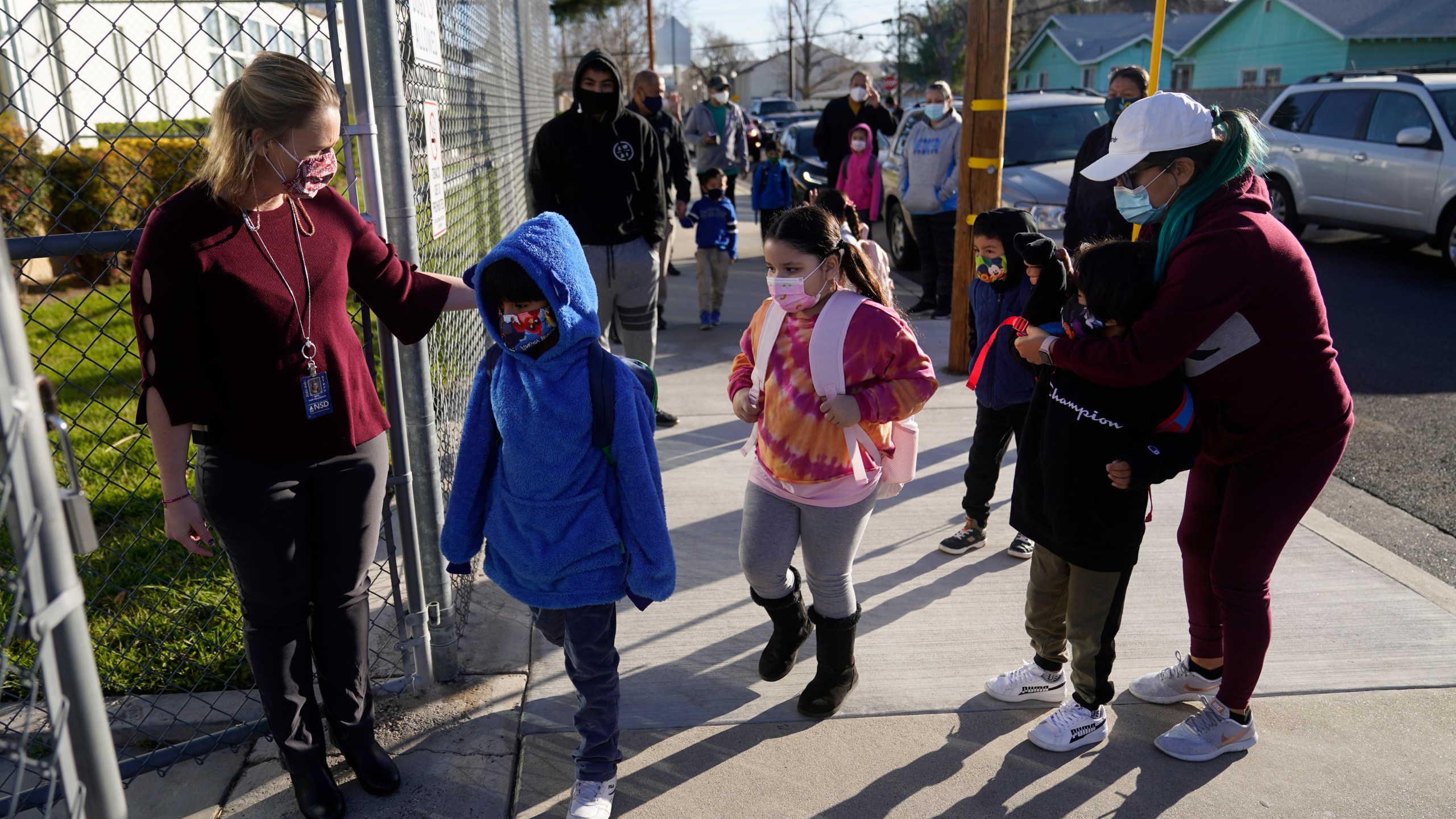 Assistant Principal Janette Van Gelderen, left, welcomes students at Newhall Elementary School in Santa Clarita on Feb. 25, 2021. Elementary school students returned to school this week in the Newhall School District. (Marcio Jose Sanchez / Associated Press)