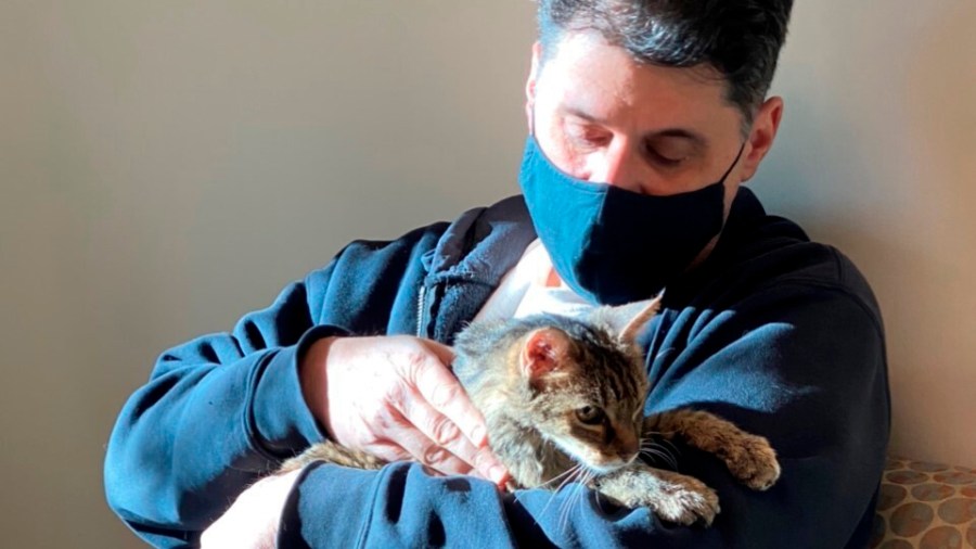 This photo provided by the Los Angeles County Department of Animal Care and Control shows Brandy, a brown tabby cat, that was reunited on Feb. 22, 2021, with her owner, Charles, (he would only give his first name) after she went astray for 15 years. They are seen together at the Palmdale animal care center.