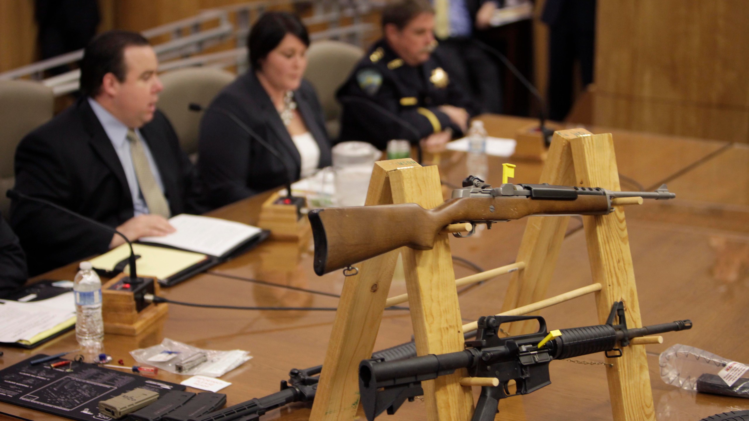 Semi-automatic rifles and large capacity magazines are displayed during a joint legislative informational hearing about gun control at the Capitol in Sacramento on Jan. 29, 2013. (Steve Yeater / Associated Press)