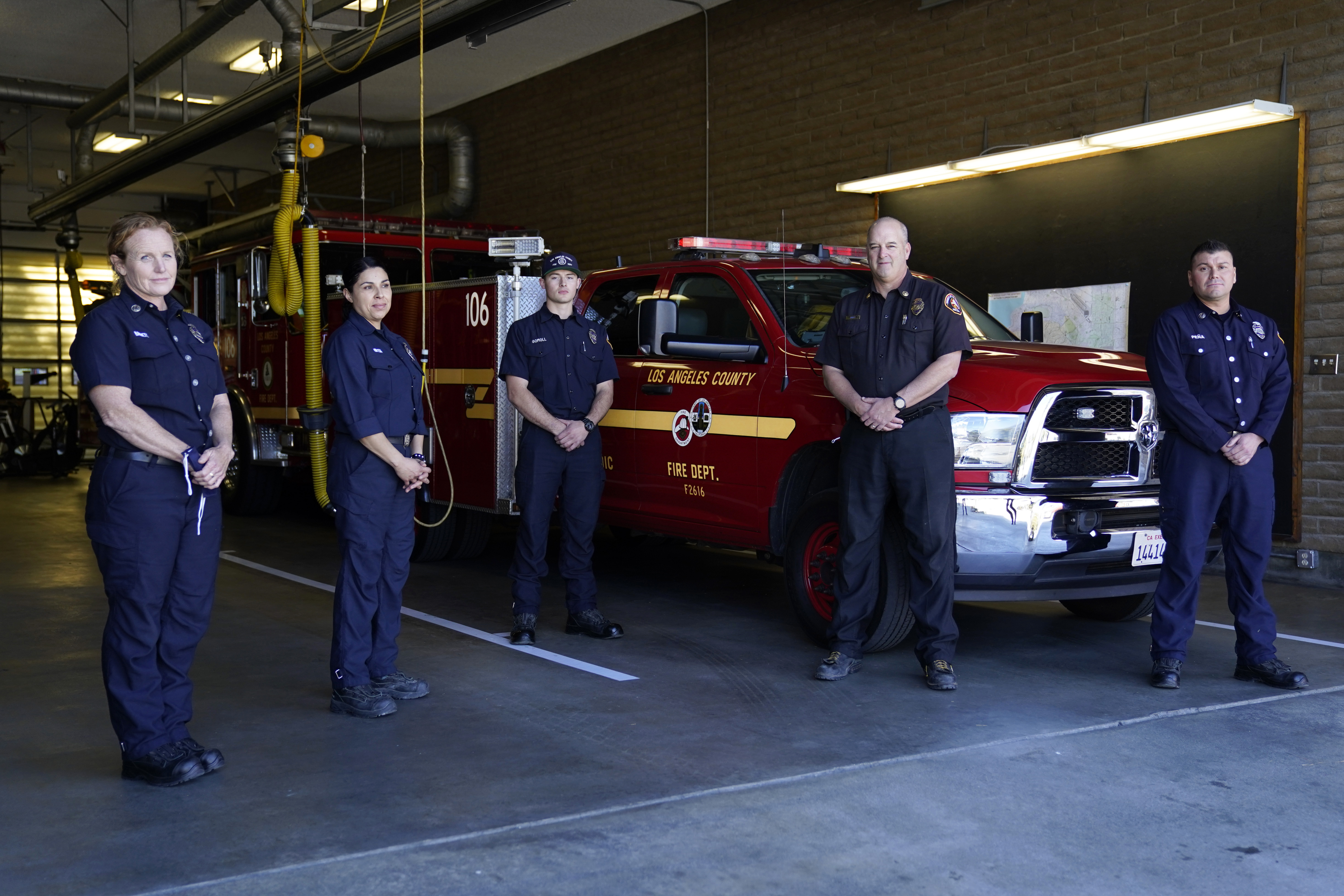 From left, fire Truck Captain Jeane Barrett, firefighter paramedic Sally Ortega, engine probationary firefighter Cole Gomoll, Battalion Chief Dean Douty, and Engine Captain Joe Peña, all first responders from Los Angeles County Fire Department - Station 106, pose for a photo at their station in Rancho Palos Verdes on Feb. 26, 2021. (Ashley Landis / Associated Press)