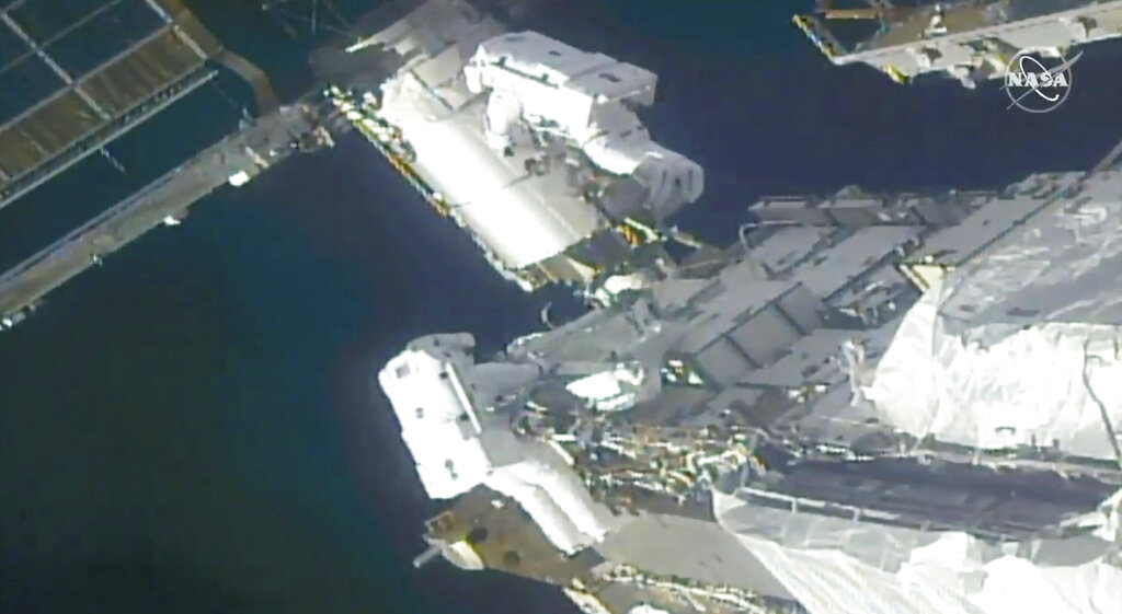 In this image taken from NASA video, NASA astronauts Kate Rubins, top, and Victor Glover work outside the International Space Station Sunday, Feb. 28, 2021. The