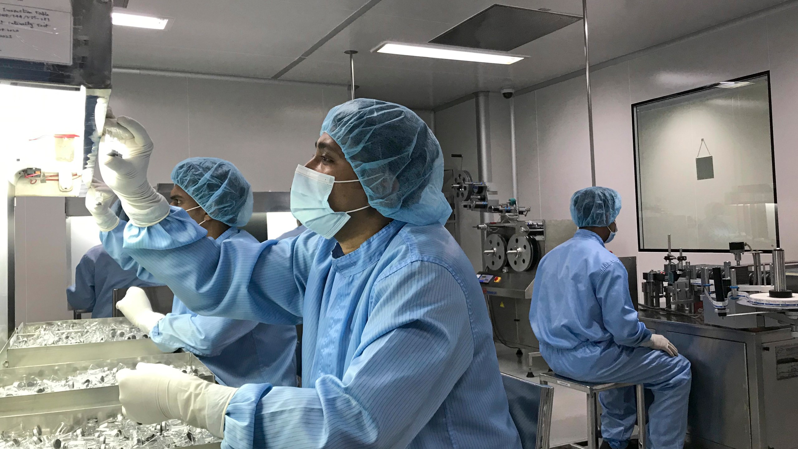 Production personnel perform a visual inspection of filled vaccine vials inside the Incepta plant on the outskirts of Dhaka in Bangladesh Saturday Feb. 13, 2021. (AP Photo/Al-emrun Garjon)