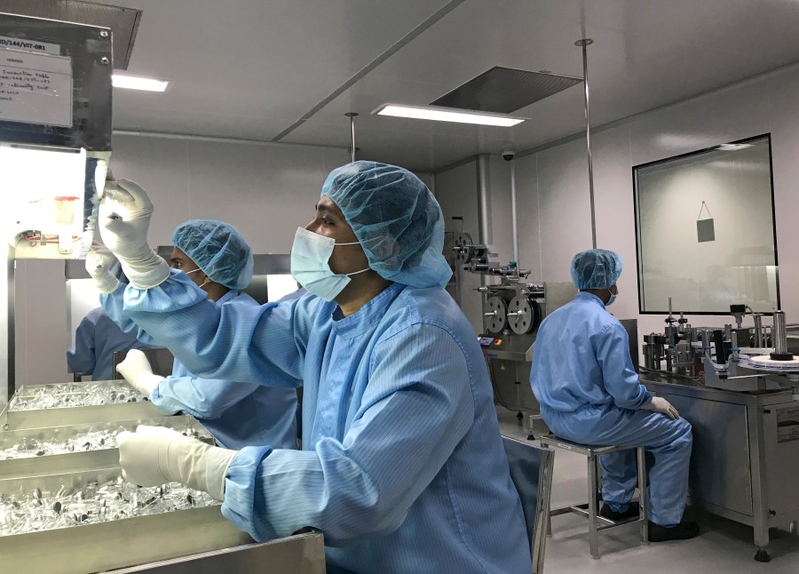 Production personnel perform a visual inspection of filled vaccine vials inside the Incepta plant on the outskirts of Dhaka in Bangladesh Saturday Feb. 13, 2021. (AP Photo/Al-emrun Garjon)