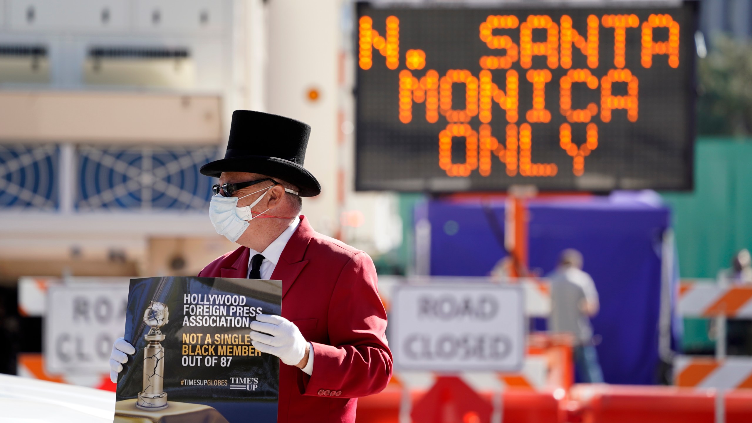 Gregg Donovan demonstrates with a sign protesting the lack of Black members in the Hollywood Foreign Press Association, outside a road closure near the 78th Golden Globe Awards at the Beverly Hilton, Sunday, Feb. 28, 2021, in Beverly Hills, Calif. (AP Photo/Chris Pizzello)