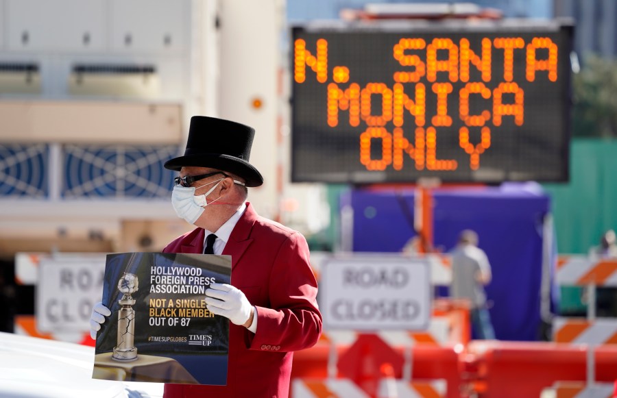 Gregg Donovan demonstrates with a sign protesting the lack of Black members in the Hollywood Foreign Press Association, outside a road closure near the 78th Golden Globe Awards at the Beverly Hilton, Sunday, Feb. 28, 2021, in Beverly Hills, Calif. (AP Photo/Chris Pizzello)