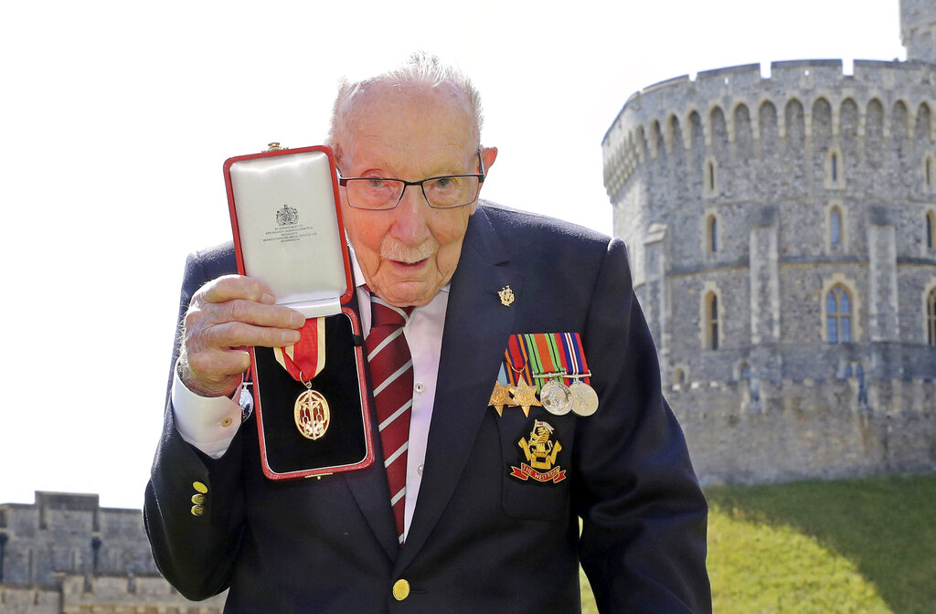 Captain Sir Thomas Moore poses for the media after receiving his knighthood from Britain's Queen Elizabeth, during a ceremony at Windsor Castle in Windsor, England in July 2020. The 100-year-old World War II veteran who captivated the British public in the early days of the coronavirus pandemic with his fundraising efforts, died Tuesday Feb. 2, 2021. (Chris Jackson/Pool Photo via AP, File)