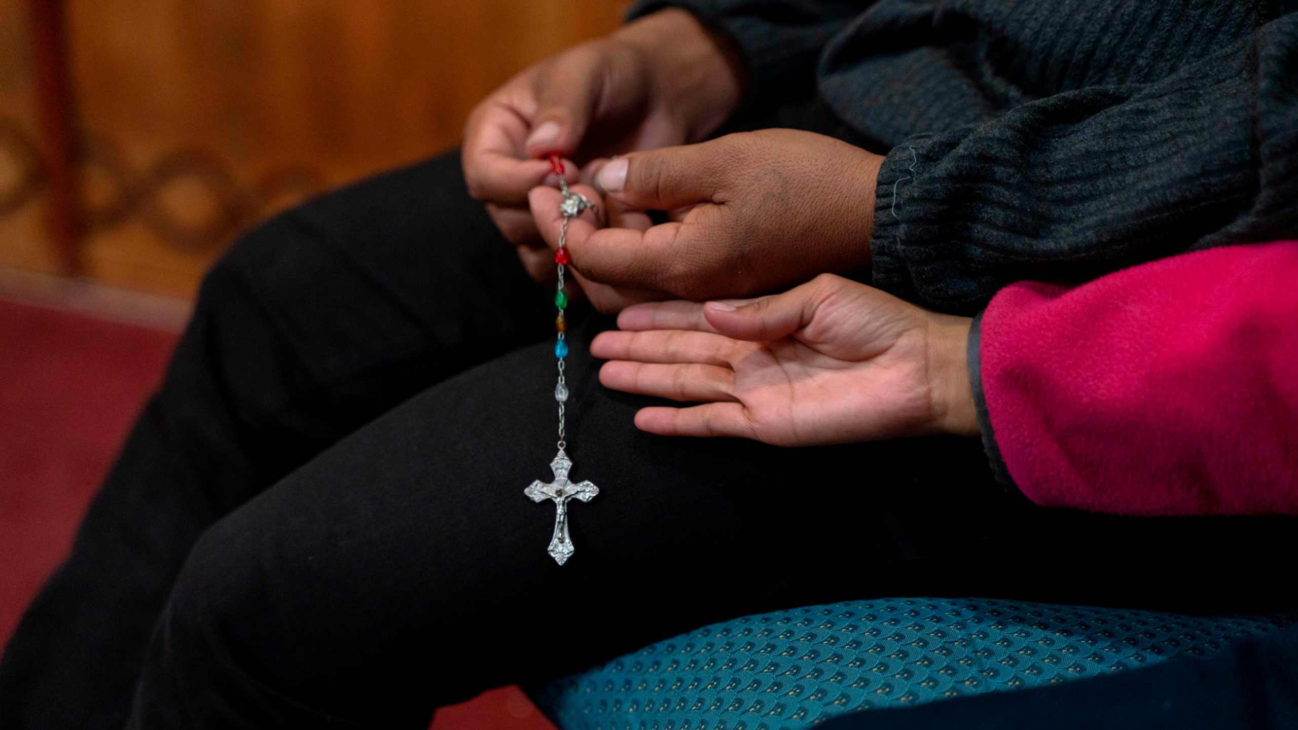 A Guatemalan man prays the Rosary with his daughter in the chapel at Holy Cross Retreat Center, which has been hosting groups of migrants that were part of the 1,300 released by Immigration and Customs Enforcement over the Christmas holiday, in Las Cruces, New Mexico, on Dec. 27, 2018. The shelter takes in groups of migrants weekly, but received this one unexpectedly as did the entire system run by Annunciation House in El Paso, Texas. (Paul Ratje / AFP via Getty Images)