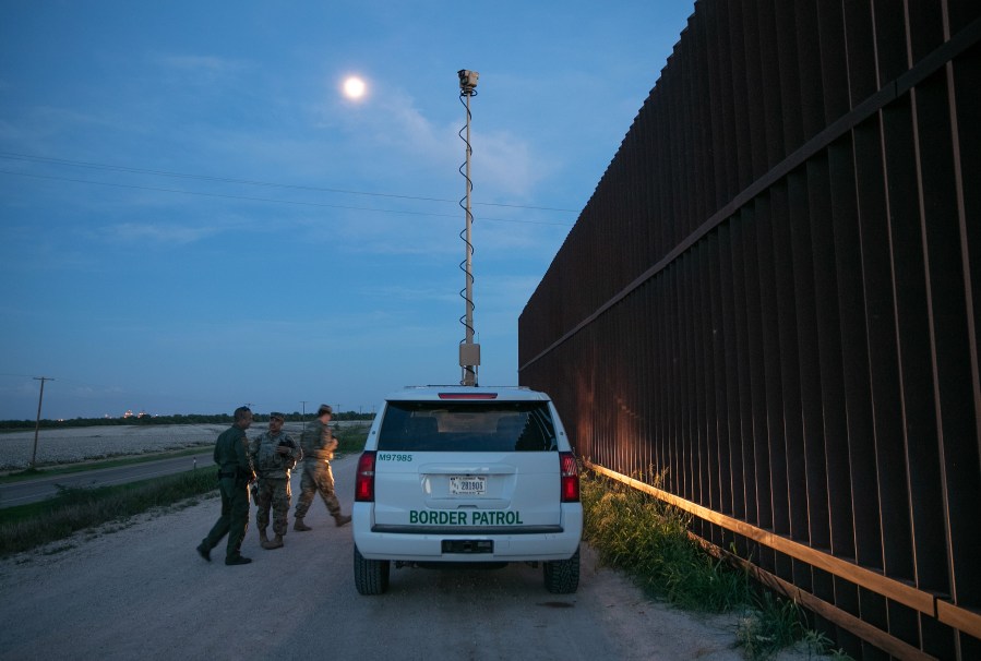 Active duty U.S. Army soldiers and a Border Patrol agent coordinate while manning a high-res surveillance camera at the U.S.-Mexico border fence at dusk on September 10, 2019 in Penitas, Texas. (John Moore/Getty Images)