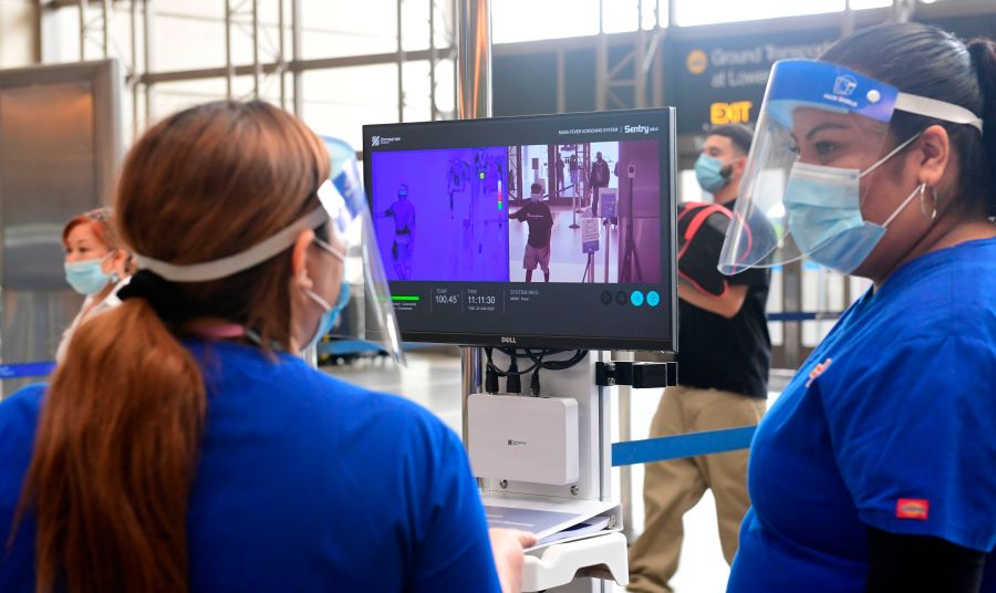 Passengers walks past thermal cameras, that check passenger's body temperatures, at Los Angeles International Airport on June 23, 2020. (FREDERIC J. BROWN/AFP via Getty Images)