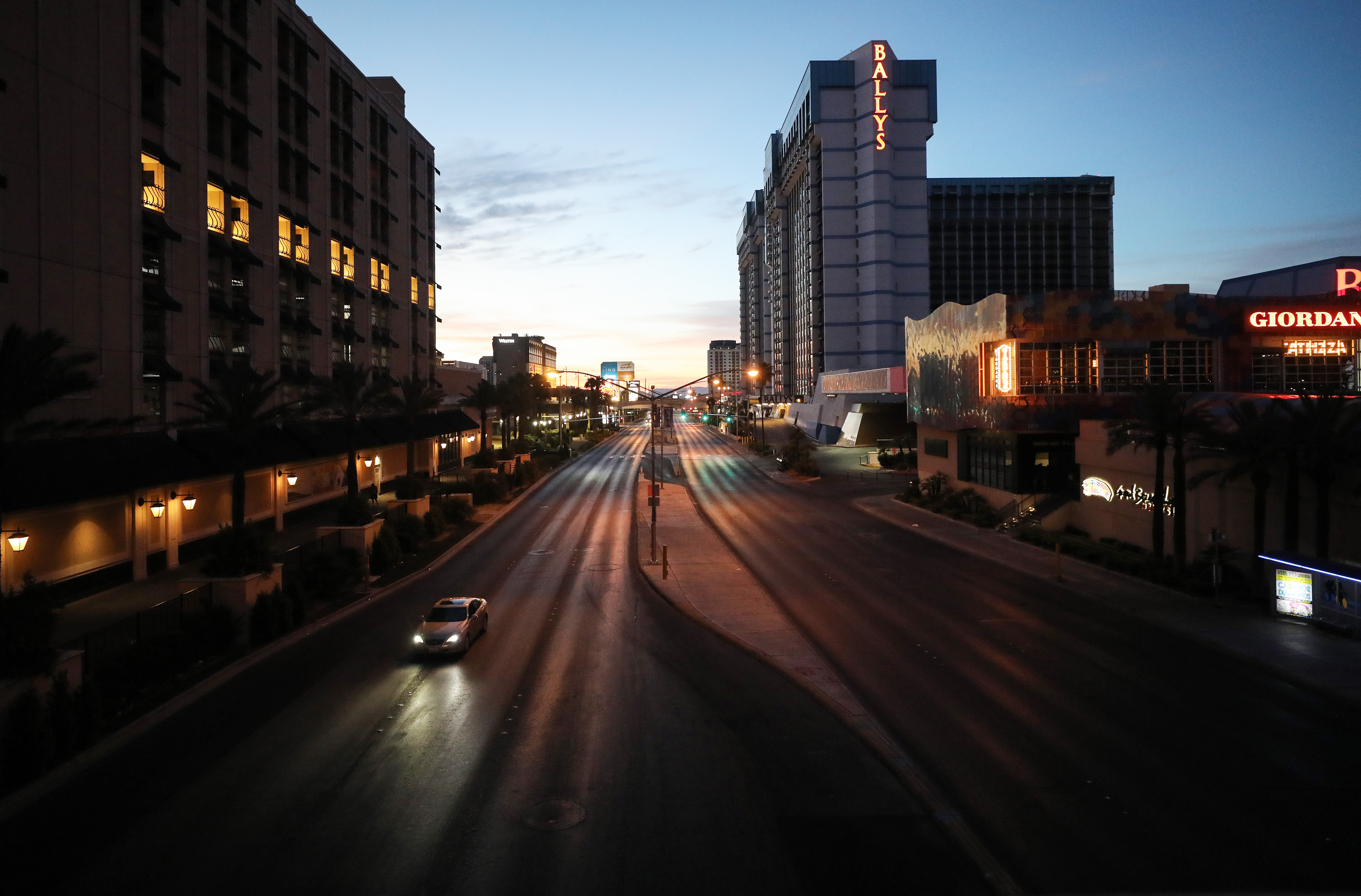 Light traffic passes on a street adjacent to the Las Vegas Strip at dawn, where most businesses have been closed since March 17 in response to the coronavirus (COVID-19) pandemic, on May 27, 2020 in Las Vegas, Nevada.(Mario Tama/Getty Images)