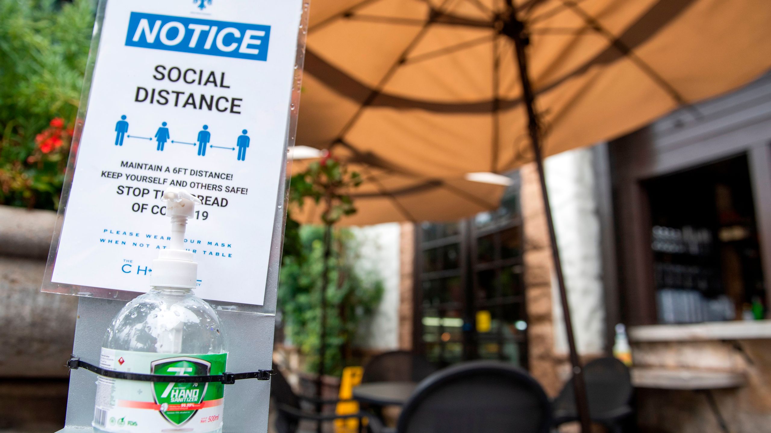 A notice calling for patrons to social distance along with hand sanitizer are seen in the outdoor seating area of The Abbey Food & Bar on January 29, 2021 in West Hollywood, California. (VALERIE MACON/AFP via Getty Images)