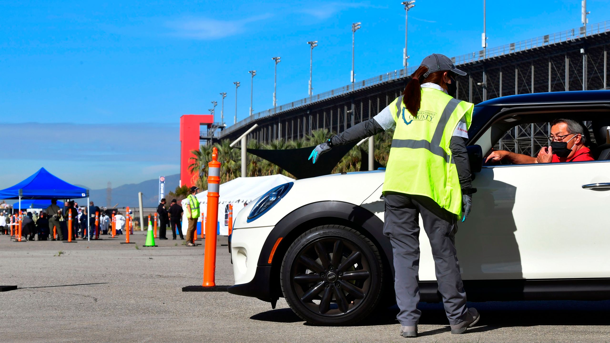 People arrive for their COVID-19 vaccine at the Auto Club Speedway in Fontana on Feb. 2, 2021. (Frederic J. Brown / AFP / Getty Images)