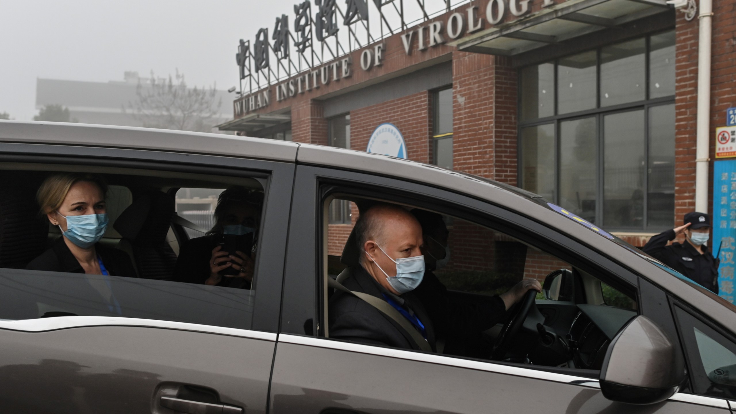 Peter Daszak, right, Thea Fischer, left, and other members of the World Health Organization team investigating the origins of the COVID-19 pandemic arrive at the Wuhan Institute of Virology in Wuhan in China's central Hubei province on Feb. 3, 2021. (Hector Retamal / AFP / Getty Images)