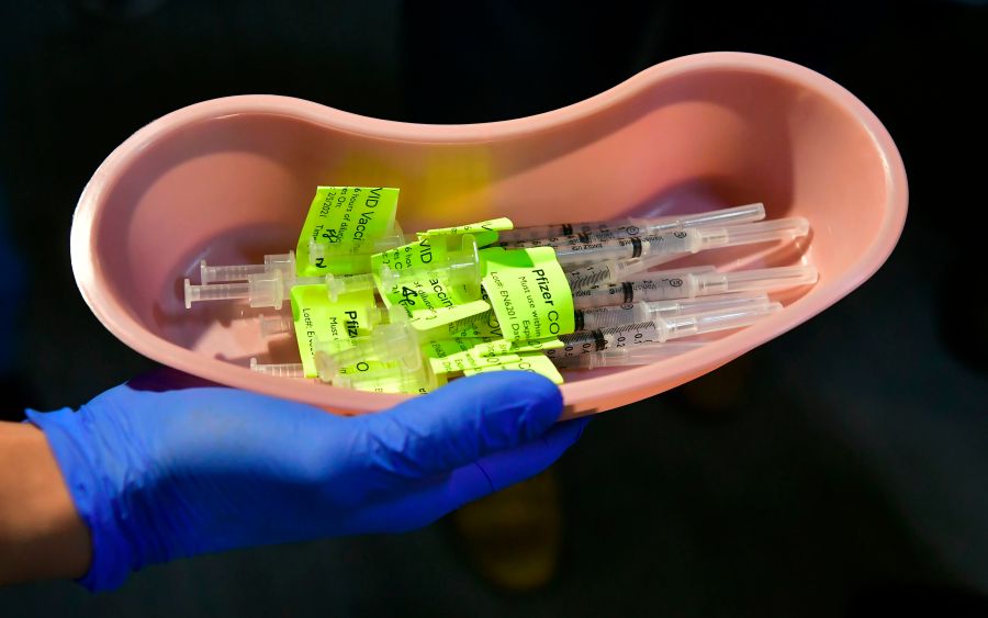 Syringes filled with the Pfizer COVID-19 vaccine are displayed on the opening day of a large-scale vaccination site at a parking structure in Pomona on Feb. 5, 2021. (FREDERIC J. BROWN/AFP via Getty Images)