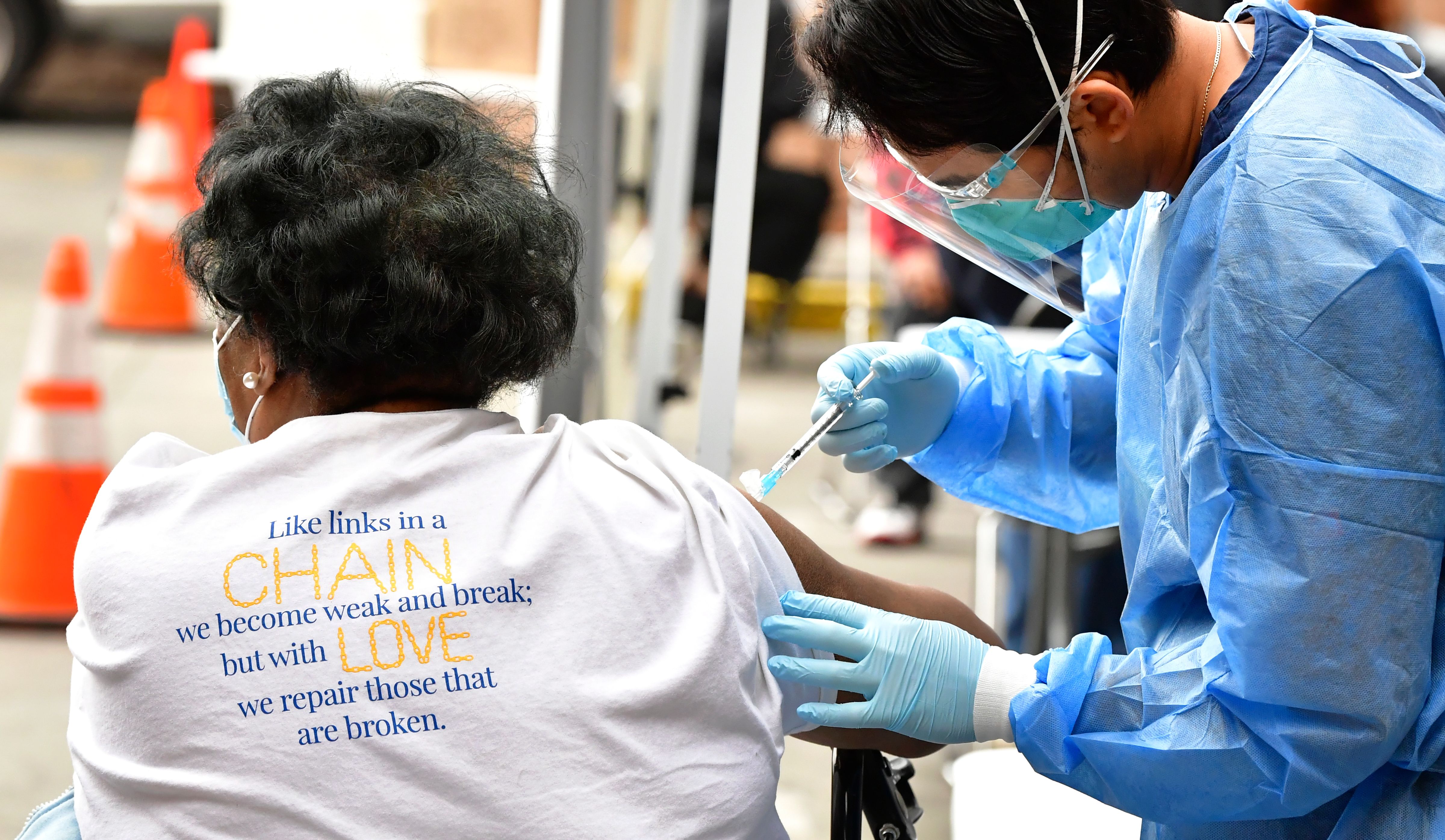 Registered Nurse Angelo Bautista administers the Moderna COVID-19 vaccine during a distribution of vaccines to seniors above the age of 65 who are experiencing homelessness at the Los Angeles Mission, in the Skid Row area of downtown Los Angeles, on Feb. 10, 2021. (Frederic J. Brown / AFP / Getty Images)