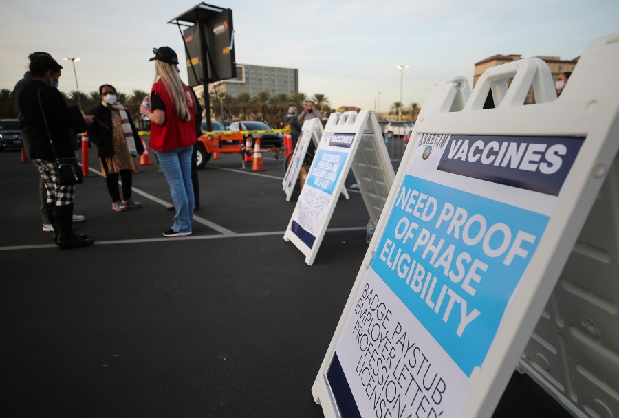 A sign is posted about proof of eligibility at a mass COVID-19 vaccination site in a parking lot of Disneyland Resort in Anaheim on Jan. 13, 2021. (Mario Tama / Getty Images)