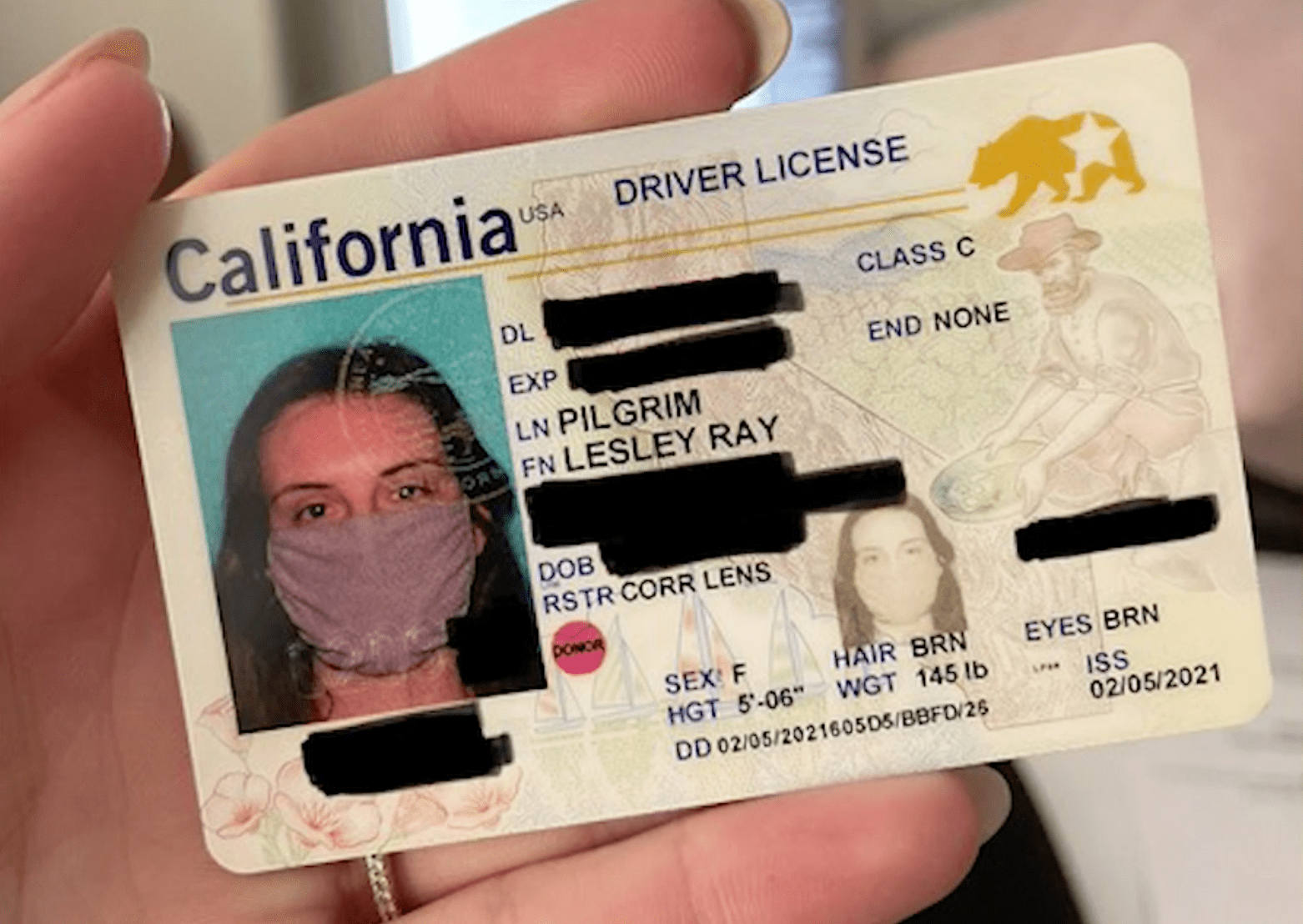 Lesley Pilgrim, 25, shared this ID card she got from the DMV that features her in a face mask.