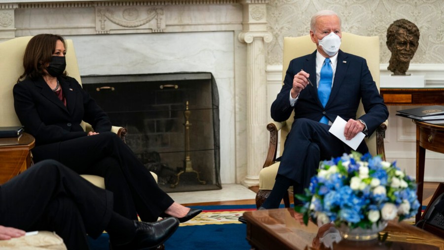 Vice President Kamala Harris listens as President Joe Biden speaks during a meeting with a bipartisan group of mayors and governors to discuss a coronavirus relief package, in the Oval Office of the White House, Friday, Feb. 12, 2021, in Washington. (AP Photo/Evan Vucci)