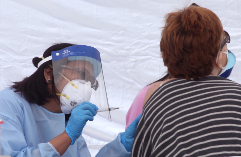 A nurse gives a woman a COVID-19 vaccine Feb. 3 at a vaccine site in the El Sereno neighborhood of Los Angeles. (Genaro Molina/Los Angeles Times)