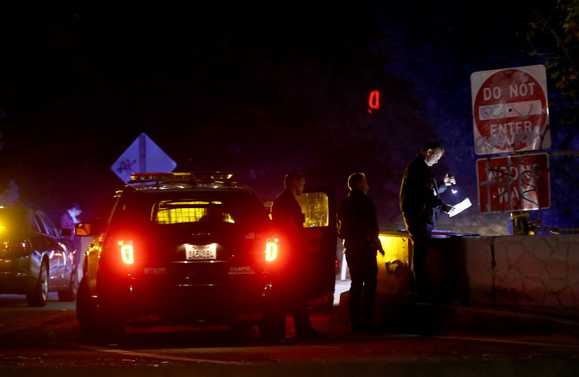 Police investigate the scene of a shooting near an offramp of the 110 Freeway in Montecito Heights on Monday. (Luis Sinco / Los Angeles Times)