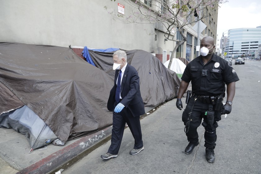 U.S. District Court Judge David O. Carter tours Los Angeles’ skid row with LAPD Officer Deon Joseph in April 2020. (Myung J. Chun / Los Angeles Times)